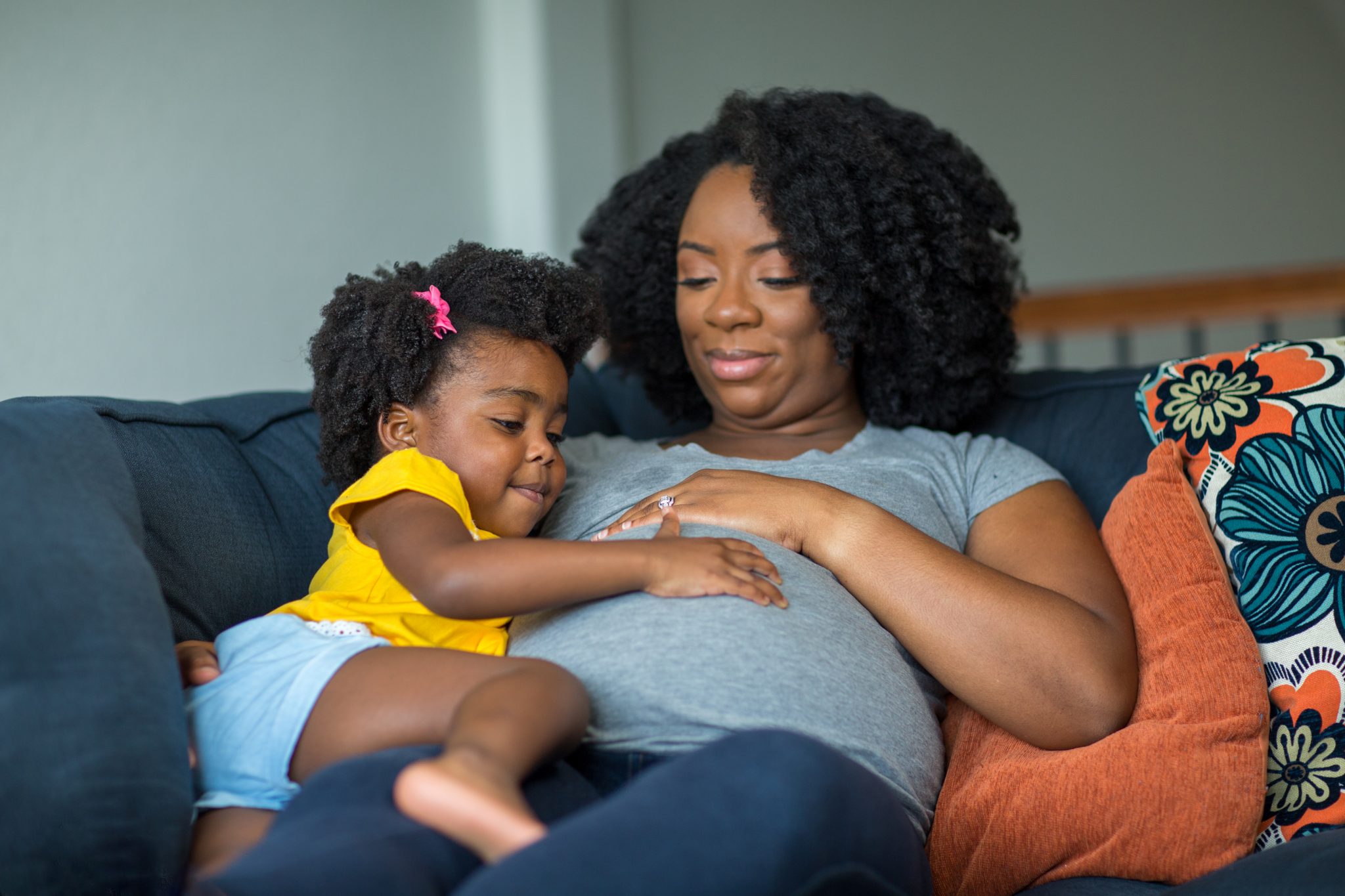 African American mother and daughter smiling at home.

