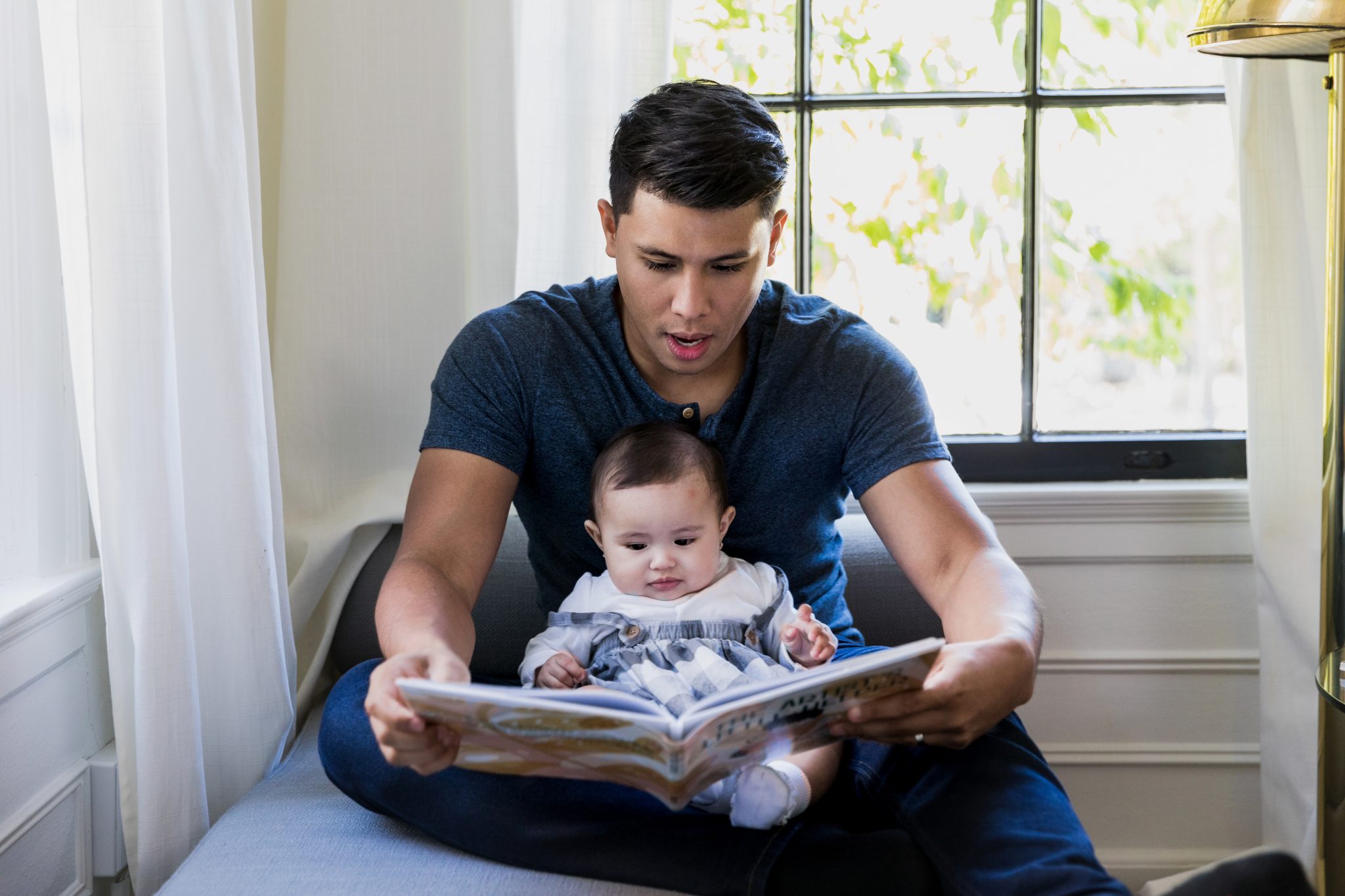 During playtime, the father and daughter read a story book together.