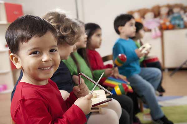 Children smiling while playing instruments